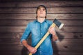 Composite image of front view of hipster standing with axe