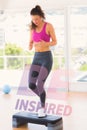 A Composite image of full length of a fit woman performing step aerobics exercise Royalty Free Stock Photo