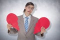 Composite image of geeky businessman crying and holding broken heart card Royalty Free Stock Photo