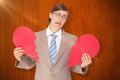 Composite image of geeky businessman crying and holding broken heart card Royalty Free Stock Photo