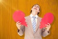 Composite image of geeky businessman crying and holding broken heart card Royalty Free Stock Photo