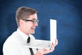 Composite image of geeky businessman holding his laptop Royalty Free Stock Photo