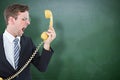 Composite image of geeky businessman shouting at telephone Royalty Free Stock Photo