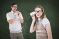A Composite image of geeky hipster couple speaking with tin can phone
