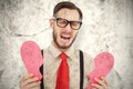 A Composite image of geeky hipster crying and holding broken heart card Royalty Free Stock Photo