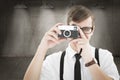 Composite image of geeky hipster holding a retro camera Royalty Free Stock Photo