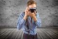 Composite image of geeky hipster holding a retro camera Royalty Free Stock Photo