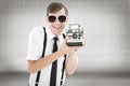 Composite image of geeky hipster holding a retro camera Royalty Free Stock Photo