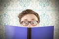 Composite image of geeky student reading a book Royalty Free Stock Photo