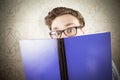 Composite image of geeky student reading a book Royalty Free Stock Photo