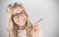 Composite image of gorgeous smiling blonde hipster holding pen Royalty Free Stock Photo