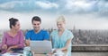 Composite image of group of people using laptop against cityscape in background Royalty Free Stock Photo