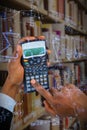 Composite image of hands of businessman using calculator