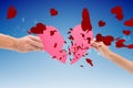 Composite image of hands holding two halves of broken heart Royalty Free Stock Photo