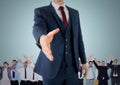 Composite image of Handshake in front of business people with blue background