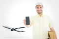 Composite image of handsome delivery man showing mobile phone