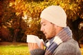 Composite image of handsome man in winter fashion blowing his nose Royalty Free Stock Photo