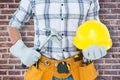 Composite image of handyman holding hammer and hard hat Royalty Free Stock Photo