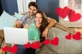 Composite image of hanging red hearts and couple doing online shopping Royalty Free Stock Photo