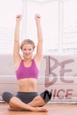 A Composite image of happy blonde sitting in lotus pose with arms up Royalty Free Stock Photo