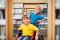 Composite image of happy boy pushing friend on wheelchair Royalty Free Stock Photo