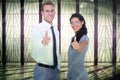 Composite image of happy business people looking at camera with thumbs up Royalty Free Stock Photo