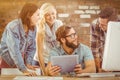 Composite image of happy business people using digital tablet at computer desk Royalty Free Stock Photo