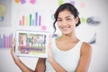 Composite image of happy businesswoman showing digital tablet in creative office Royalty Free Stock Photo