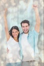 Composite image of happy casual couple cheering together Royalty Free Stock Photo