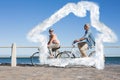 Composite image of happy casual couple going for a bike ride on the pier