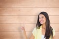 Composite image of happy casual woman pointing up Royalty Free Stock Photo