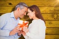 Composite image of happy couple holding gift Royalty Free Stock Photo