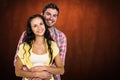 Composite image of happy couple hugging and looking at camera Royalty Free Stock Photo