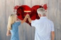 Composite image of happy couple painting wall with roller Royalty Free Stock Photo