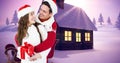 Composite image of happy couple in santa hats with snow covered land in background, copy space Royalty Free Stock Photo