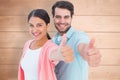 Composite image of happy couple showing thumbs up Royalty Free Stock Photo