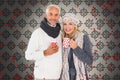 Composite image of happy couple in winter fashion holding mugs