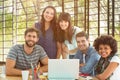 Composite image of happy creative business team gathered around a laptop Royalty Free Stock Photo