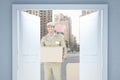 Composite image of happy delivery man carrying cardboard box Royalty Free Stock Photo