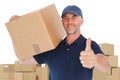 Composite image of happy delivery man holding cardboard box showing thumbs up Royalty Free Stock Photo