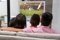 Composite image of happy family watching tv on the sofa Royalty Free Stock Photo