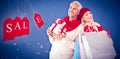 Composite image of happy festive couple with gifts and bags