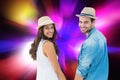Composite image of happy hipster couple holding hands and smiling at camera Royalty Free Stock Photo