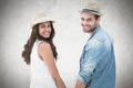 Composite image of happy hipster couple holding hands and smiling at camera Royalty Free Stock Photo