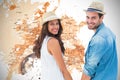 Composite image of happy hipster couple holding hands and smiling at camera Royalty Free Stock Photo