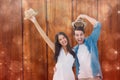 Composite image of happy hipster couple smiling at camera and cheering Royalty Free Stock Photo