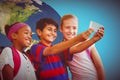 Composite image of happy kids taking selfie in school corridor Royalty Free Stock Photo