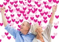 Composite image of happy mature couple with hands up Royalty Free Stock Photo