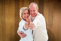 Composite image of happy mature couple showing thumbs up Royalty Free Stock Photo