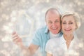 Composite image of happy older couple holding house shape Royalty Free Stock Photo